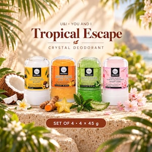Op de afbeelding: Een set van vier U&I Tropical Escape kristal deodorantsticks, elk 45 gram. De geuren omvatten kokosnoot, kurkuma en stervrucht, groene thee en aloë vera, en kersenbloesem, weergegeven met hun respectievelijke natuurlijke ingrediënten.