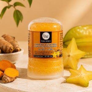 Könnte beinhalten: Ein zylindrischer Deostift mit einer durchscheinenden, orangefarbenen Kristalltextur. Das Etikett trägt die Aufschrift U&I YOU AND I TURMERIC & STAR FRUIT ALUM CRYSTAL DEODORANT, No Preservatives & Alcohol Free, For all skin types, 45 g. Der Behälter hat eine durchsichtige Kappe.