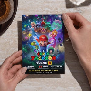 Puede incluir: Invitaci&oacute;n de cumplea&ntilde;os colorida con personajes de Super Mario. La invitaci&oacute;n incluye el texto "Super Jackson Turns 6" con la fecha, hora y lugar. El dise&ntilde;o presenta un fondo vibrante con tem&aacute;tica espacial y varios personajes.