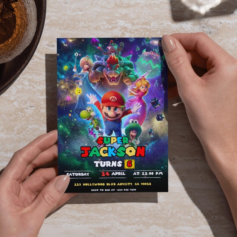 Puede incluir: Invitaci&oacute;n de cumplea&ntilde;os colorida con personajes de Super Mario. La invitaci&oacute;n incluye el texto "Super Jackson Turns 6" con la fecha, hora y lugar. El dise&ntilde;o presenta un fondo vibrante con tem&aacute;tica espacial y varios personajes.