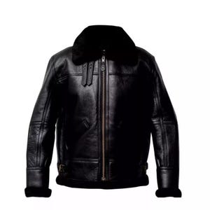 Puede incluir: Chaqueta de cuero negro con cuello y forro de borrego. La chaqueta tiene cremallera frontal, dos bolsillos delanteros y cintura con hebilla. Las mangas tienen puños de borrego. Una prenda de abrigo clásica.
