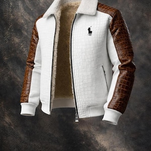 May include: White and brown textured jacket with a black logo on the chest. The jacket features brown faux leather sleeves and a white faux fur collar. The interior lining is a light brown color. The jacket has a zipper closure.