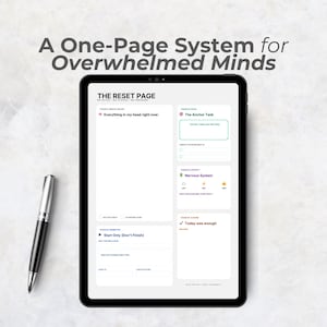 May include: A black tablet showing a "The Reset Page" template with areas for tasks and notes. A silver and black pen is on the surface. The text "A One-Page System for Overwhelmed Minds" is at the top of the image.