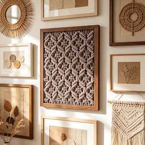 May include: A selection of framed wall art with a bohemian theme. The pieces include a macrame wall hanging, a woven mirror, and framed artwork with natural textures and neutral colours. The frames are made of wood.