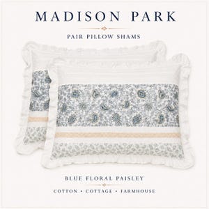 May include: A pair of Madison Park pillow shams featuring a blue floral paisley pattern on a white background. The rectangular shams have ruffled edges, a central band of intricate blue paisley, and a horizontal strip of light tan lace trim.