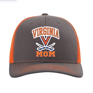 Puede incluir: Gorra de camionero gris y naranja con el texto "VIRGINIA MOM" en blanco y naranja. La gorra presenta un logotipo con espadas cruzadas y un diseño en "V".