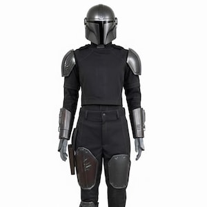 May include: A full Mandalorian costume. It features a silver helmet, shoulder armour, and gauntlets. The outfit includes a black shirt and trousers, with knee and thigh armour. A holster and leg wraps complete the ensemble. The costume is designed for cosplay.