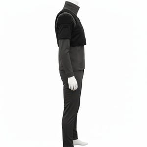 May include: A black tactical outfit comprising a mock turtleneck shirt, a cropped vest, and matching trousers. The vest has a square design and is worn over the long-sleeved shirt. The trousers are form-fitting. The outfit is displayed on a mannequin.