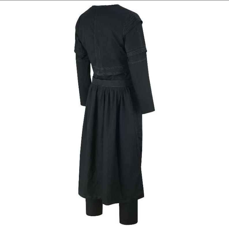 May include: A black outfit consisting of a long-sleeved top with shoulder detailing, a long skirt, and leggings. The outfit is made of a dark fabric and has a simple, elegant design. The skirt is pleated at the waist.