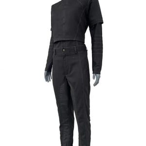 May include: A black two-piece outfit. The cropped jacket has short sleeves and long sleeves, with visible stitching. The matching trousers have a belt and a straight leg. The jacket has a high collar.