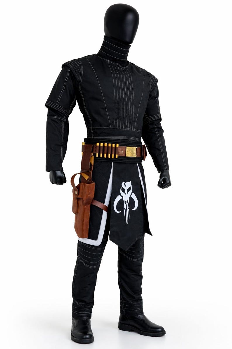 Puede incluir: Traje negro con costuras blancas, con una parte superior de cuello alto, pantalones y un cintur&oacute;n con detalles en forma de bala. Una funda marr&oacute;n y un gr&aacute;fico en blanco y negro en la falda completan el atuendo. El disfraz se exhibe en un maniqu&iacute;.