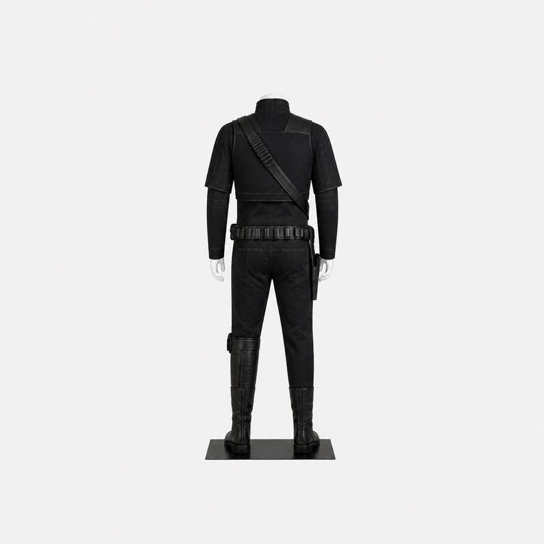 May include: A black costume on a mannequin. The outfit features a short-sleeved shirt, trousers, belt, holster, and boots. A strap crosses the chest. The mannequin stands on a black base against a white backdrop.