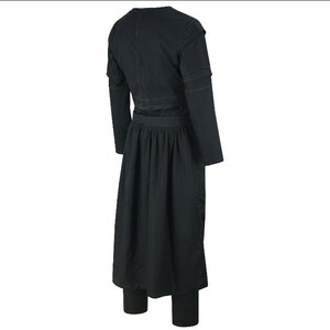 May include: A black outfit consisting of a long-sleeved top with shoulder detailing, a long skirt, and matching leggings. The outfit is made of a dark fabric and has a simple, elegant design.