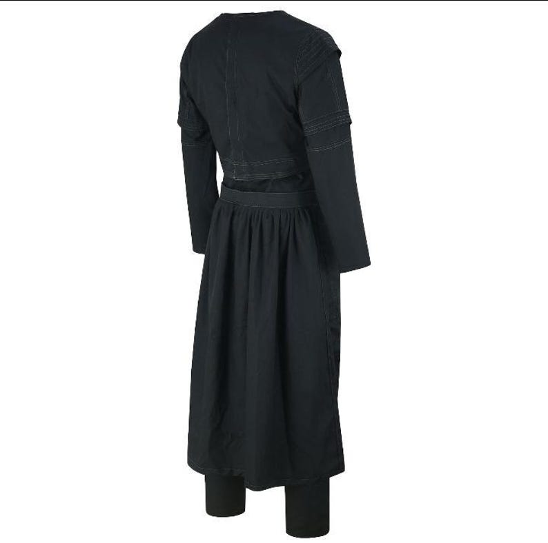 May include: A black outfit consisting of a long-sleeved top with shoulder detailing, a long skirt, and matching leggings. The outfit is made of a dark fabric and has a simple, elegant design.