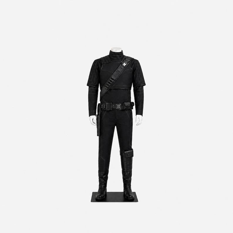 May include: A black costume displayed on a mannequin. The outfit includes a short-sleeved top, long-sleeved undershirt, trousers, belt, holster, and boots. A strap crosses the chest. The mannequin stands on a black base.