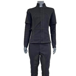 May include: A black two-piece outfit comprising a jacket and trousers. The jacket has a high collar, short sleeves, and contrasting stitching. The trousers feature a distinctive panel design. The outfit is displayed on a mannequin.