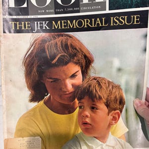 May include: Vintage "LOOK" magazine cover from November 17, 1964, featuring a portrait of a woman and a young boy. The magazine's title, "LOOK," is prominently displayed at the top, with the text "THE JFK MEMORIAL ISSUE" below.