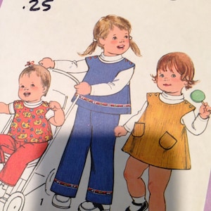 May include: A vintage sewing pattern for children's clothing. The pattern includes instructions for making a dress, a jumper, and a pair of pants. The pattern is for sizes 1/2 and 1, toddler. The pattern number is 8716.