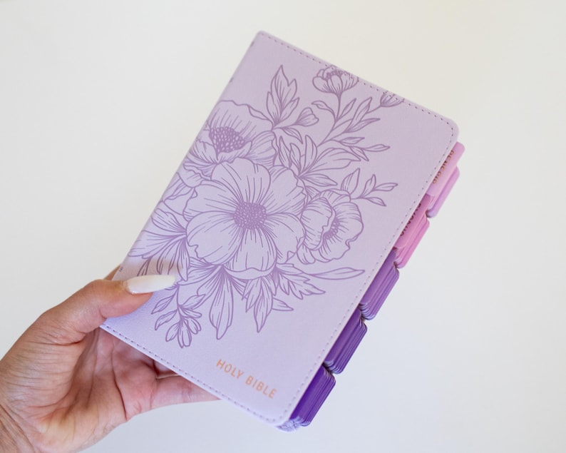 Custom engraved KJV Bible for women showcasing a soft purple leather binding, personalized name on the front cover, coordinating pink tabs, and traditional King James Version scripture, making a beautiful Christian keepsake gift for her faith journey