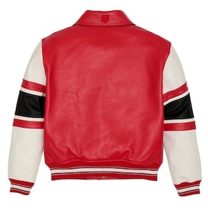 May include: A red varsity jacket with white sleeves and black and red stripes. The jacket has a ribbed hem and cuffs with white stripes. A small emblem is visible on the collar.