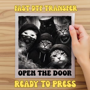 May include: A black and white image featuring a group of cats wearing hoodies and bandanas. The text "FAST DTF TRANSFER", "OPEN THE DOOR", and "READY TO PRESS" are displayed in yellow and black fonts. The image is held by a person.