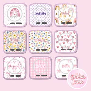 Pode incluir: Nove carregadores de telefone personalizados com vários designs. Cada carregador apresenta um nome em uma moldura circular. Os designs incluem arco-íris, padrões florais, corações e laços, todos em cores pastel. Os carregadores são quadrados com cantos arredondados e uma pequena porta de carregamento.