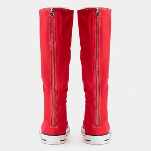 Puede incluir: Un par de botas altas de lona roja con una cremallera met&aacute;lica vertical de arriba a abajo en la parte posterior de cada ca&ntilde;a. Las botas tienen una suela de goma blanca con una fina raya negra y un dise&ntilde;o de puntera redondeada.