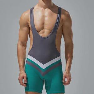 Puede incluir: Un maillot de lucha gris y verde azulado con un diseño en forma de V en la parte delantera. El maillot tiene cuello redondo y tirantes. La parte inferior es verde azulado, con rayas blancas y grises. La prenda es ajustada.
