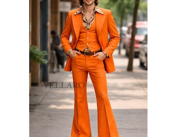 Puede incluir: Un traje naranja de tres piezas con pantalones acampanados. El traje incluye una americana, un chaleco y un pantalón. El modelo lleva una camisa estampada y un cinturón de cuero marrón. El traje es de estilo retro.