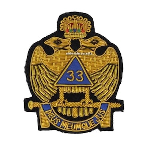 May include: Embroidered patch featuring a gold double-headed eagle design with a crown, a blue triangle with the number 33, and the text "DEUS MEUMQUE JUS" in blue. The patch is on a black background.