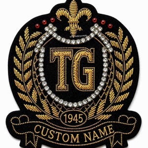 May include: Black embroidered patch with gold detailing, featuring the letters "TG" inside a circle. The patch includes a banner with "CUSTOM NAME" and the year "1945". Embellished with rhinestones and a fleur-de-lis.