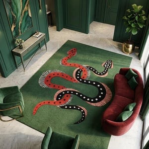 Puede incluir: Una alfombra rectangular grande con fondo verde y dos serpientes entrelazadas. Una serpiente es roja con rayas blancas y negras, mientras que la otra es negra con puntos blancos y rayas rojas. La alfombra está en una habitación con paredes verdes.
