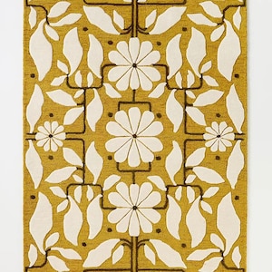 May include: Mustard yellow rectangular rug with a repeating floral pattern. The design features large white flowers, leaves, and stems outlined in dark brown. The rug has a textured appearance, adding depth to the design.
