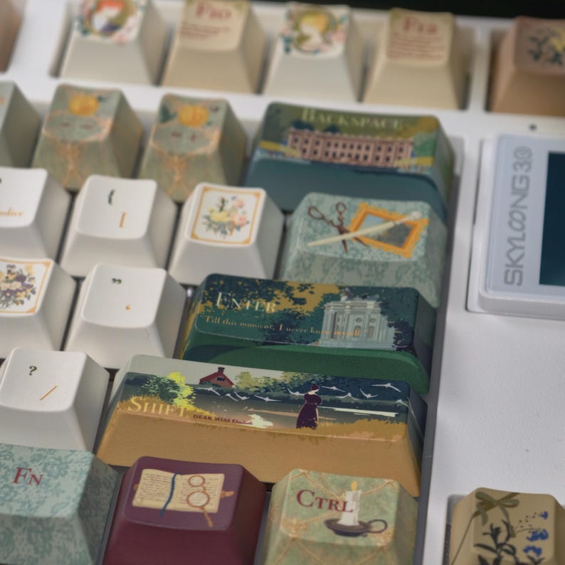 May include: A close-up of a white keyboard with custom keycaps. The keycaps feature various illustrations, including landscapes, floral designs, and text labels like "ENTER" and "SHIFT". The keycaps have a vintage aesthetic.