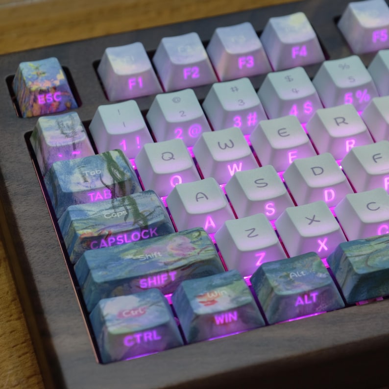May include: A mechanical keyboard featuring a dark wood frame and white keycaps with pink backlighting. The left-side modifier keys, including Esc, Tab, Caps Lock, Shift, Ctrl, Win, and Alt, feature a blue and purple impressionist art pattern.