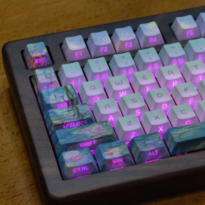 May include: A mechanical keyboard featuring a dark wood frame and white keycaps with pink backlighting. The left-side modifier keys, including Esc, Tab, Caps Lock, Shift, Ctrl, Win, and Alt, feature a blue and green impressionist art pattern.