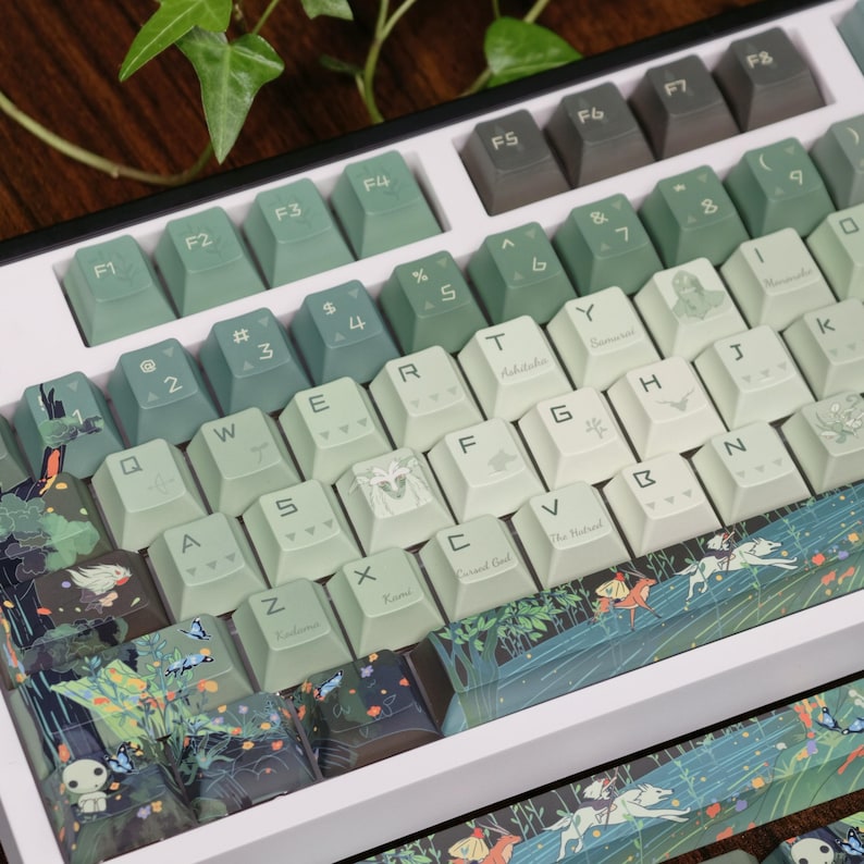May include: A custom mechanical keyboard with green and white keycaps. The keycaps feature various designs, including forest scenes, butterflies, and character illustrations. The keyboard has a white frame and a variety of function keys.