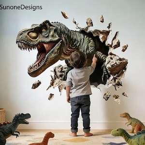 May include: A wall decal featuring a large, green, three-dimensional T-Rex dinosaur appearing to break through a wall with jagged, rocky edges. The dinosaur has an open mouth with visible teeth and yellow eyes. The text SunoneDesigns is visible.