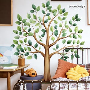 Puede incluir: Un vinilo decorativo de pared con un árbol de tronco y ramas marrones, adornado con hojas verdes. El vinilo se aplica a una pared blanca. La habitación también incluye una cama, una mesita de noche y cojines decorativos.
