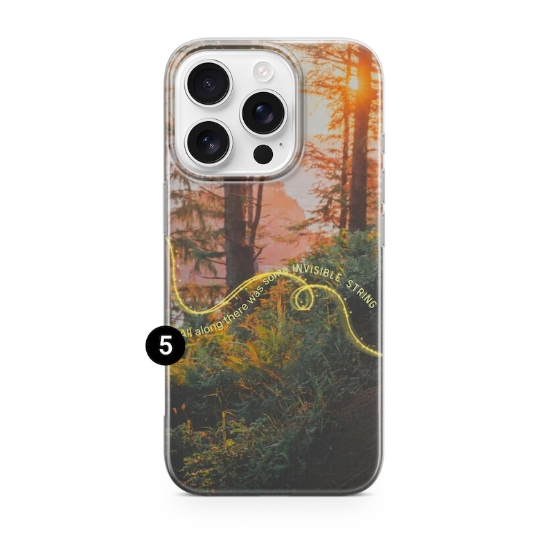 May include: A clear phone case featuring a scenic forest landscape with a sunset. The design includes the text "invisible string" and "all along there was some" in a yellow, curved font. The case has a camera cutout.