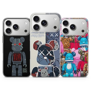 Könnte beinhalten: Drei Handyhüllen mit einzigartigen Designs. Eine zeigt einen roboterartigen Bären, eine andere einen Bären mit einem "XX"-Gesicht, und die dritte zeigt eine Vielzahl farbenfroher Bärenfiguren. Die Hüllen sind für ein Smartphone konzipiert.