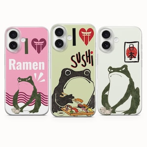 May include: Three phone cases featuring frog illustrations. The pink case says I heart Ramen with a frog eating noodles. The light green case says I heart Sushi with a frog eating sushi. The white case features a frog and a red sun symbol.