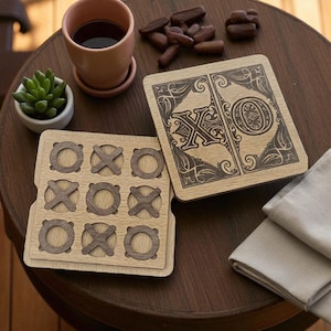 May include: Wooden tic-tac-toe game set with a decorative design. The set includes a game board with carved spaces for the X's and O's, and a separate wooden piece with the X and O symbols. The game is displayed on a dark wooden table.