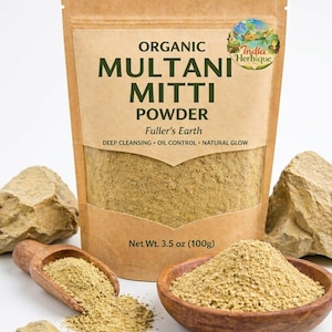 May include: A package of organic Multani Mitti powder, also known as Fuller's Earth, with the text "Deep Cleansing, Oil Control, Natural Glow." The package is displayed with a wooden scoop and bowl filled with the powder. Net weight is 3.5 oz (100g).