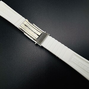 Puede incluir: Correa de reloj Breitling blanca con cierre plateado. La correa est&aacute; hecha de un material acanalado y texturizado. El logotipo de Breitling est&aacute; grabado en la correa.