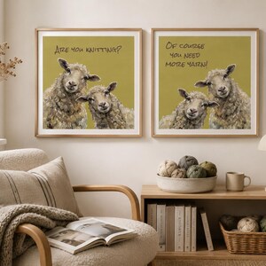 May include: Two square framed wall art prints featuring illustrations of sheep on a mustard yellow background. The left print displays the text "Are you knitting?" and the right print displays the text "Of course you need more yarn!" in black lettering.