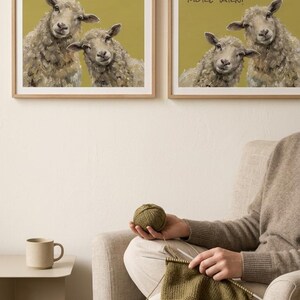 May include: Two square framed wall art prints featuring illustrations of sheep on a mustard yellow background. The left print reads Are you knitting? and the right print reads Of course you need more yarn! Both frames are light wood.