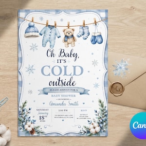 May include: A baby shower invitation card featuring a blue and white buffalo check border, a clothesline with a hat, onesie, teddy bear, socks, and mittens, and the text Oh Baby, it's COLD outside, Amanda Smith, January 18, 2020, and event details.
