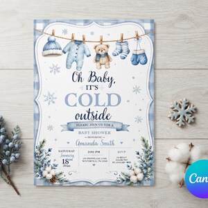 May include: A baby shower invitation card featuring a blue plaid border and a clothesline with a winter hat, onesie, teddy bear, socks, and mittens. The text reads Oh Baby, IT'S COLD outside, honoring Amanda Smith, Saturday January 18th 2024.