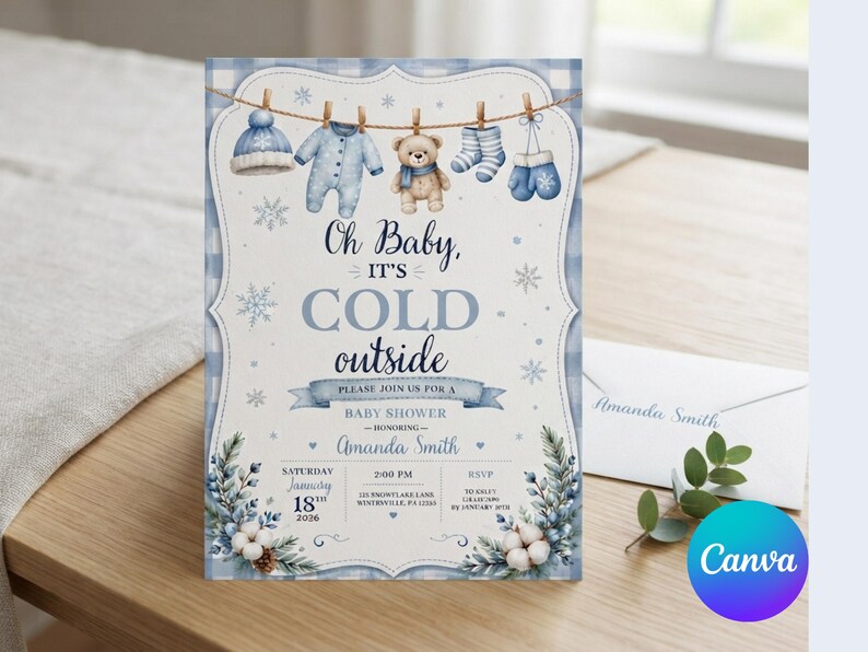 May include: A baby shower invitation card featuring a blue gingham border and a clothesline with a winter hat, onesie, teddy bear, socks, and mittens. The text reads: Oh Baby, IT'S COLD outside, PLEASE JOIN US FOR A BABY SHOWER, Amanda Smith, January 18th, 2026.